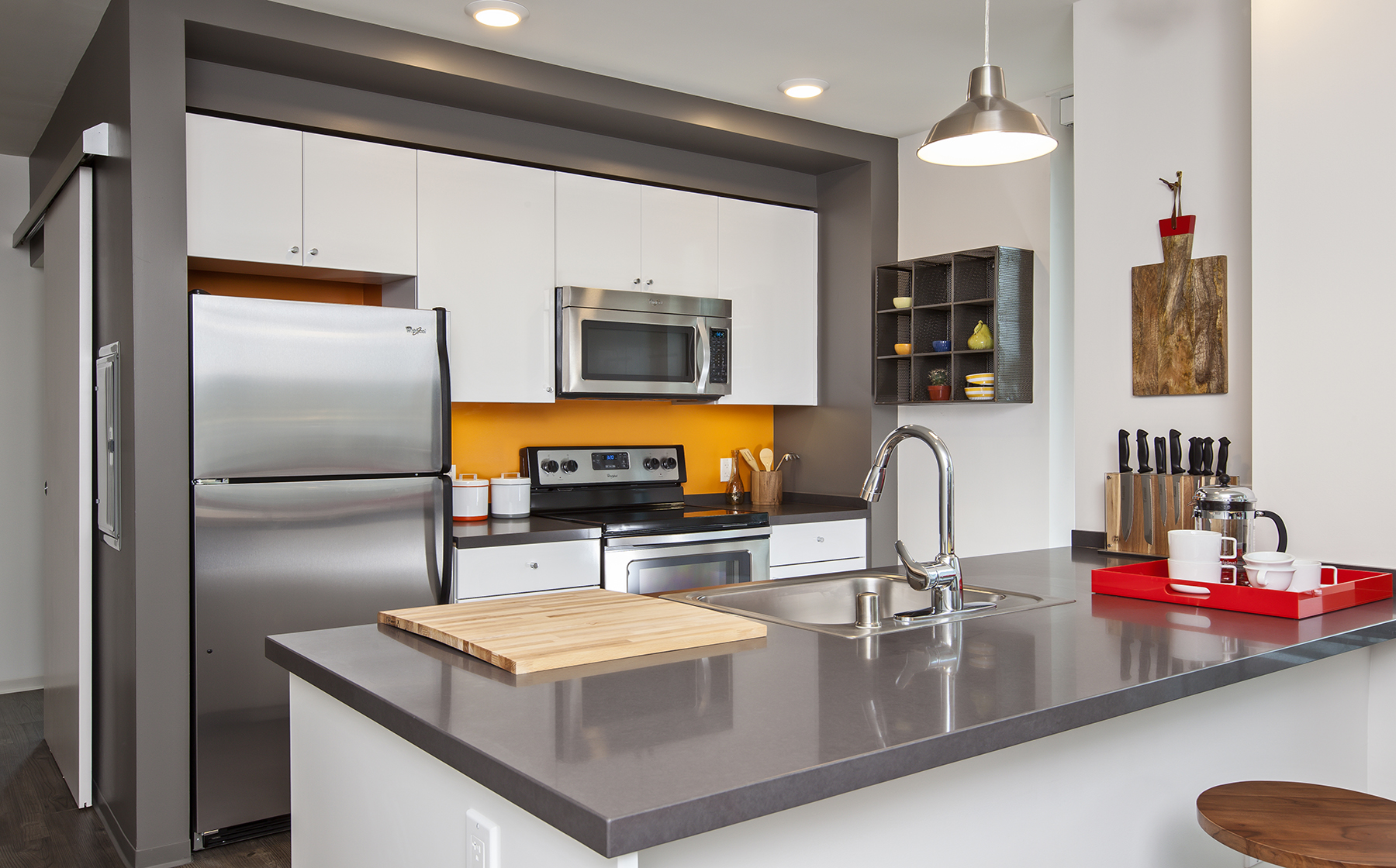 Kitchen with white cabinetry, chrome countertop and stainless steel appliances